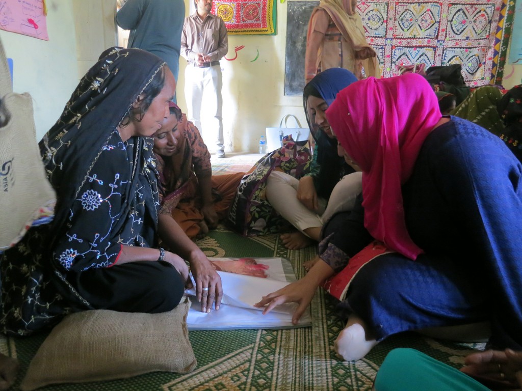 01 Students and artisans look through design ideas together